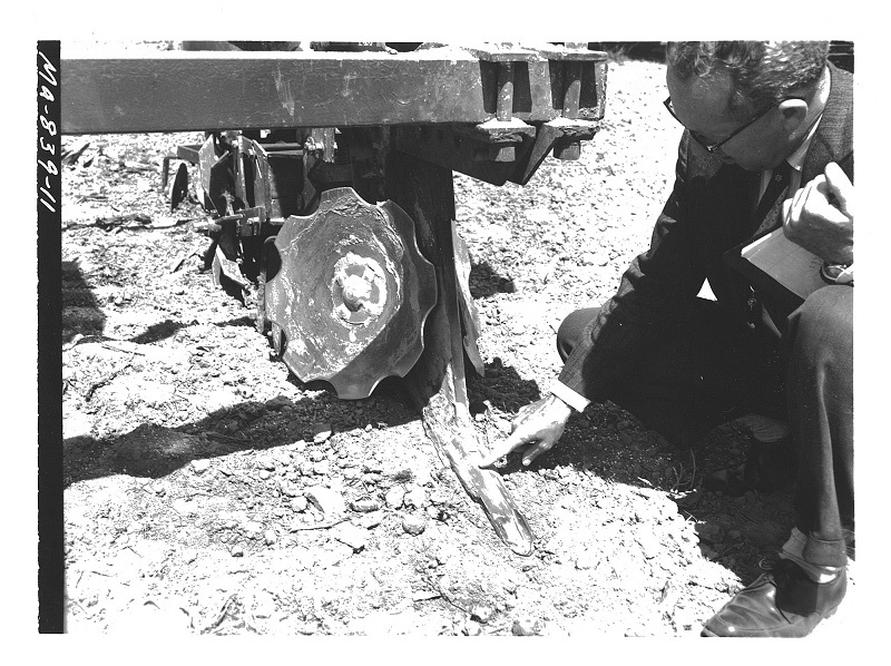 Guy Geinger from the University of Maryland inspects the subsoiler point on a Lister Planter.