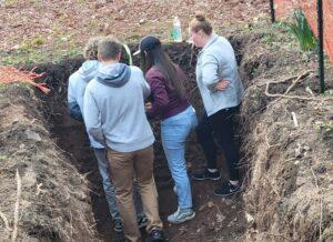 An Envirothon team anallizes soil in a soil pit.