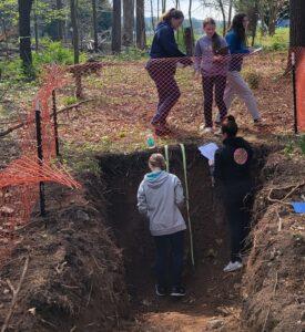 Envirothon teams work in a soil pit to analyze soil.