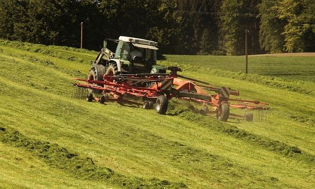 Tractor pulling a rake, turning mowed hay