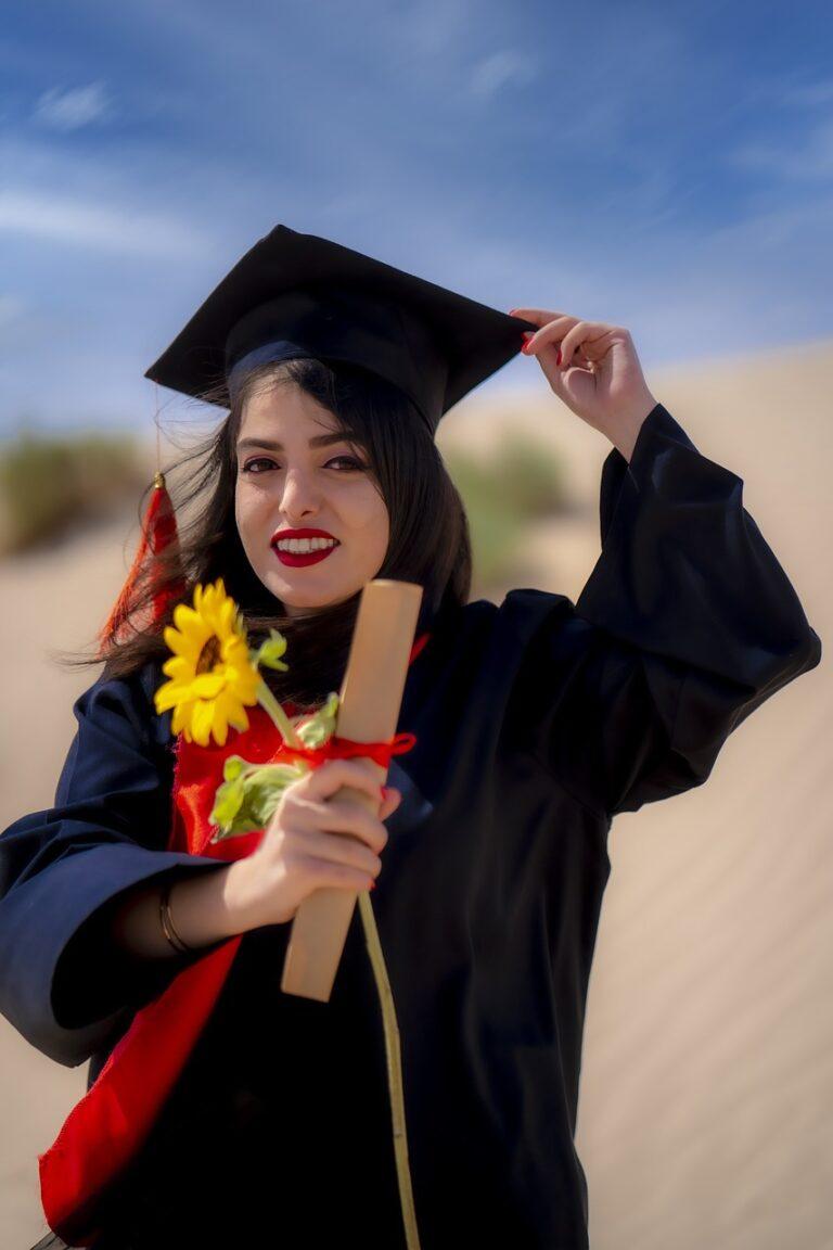 Woman in college graduation gown holding a diploma and a sunflower