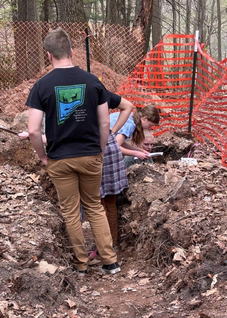 Students in a soil pit looking at soil layers